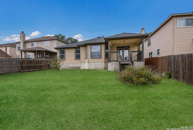 back of property featuring a yard, a fenced backyard, and a porch