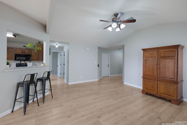 living area featuring ceiling fan, baseboards, lofted ceiling, and light wood-type flooring