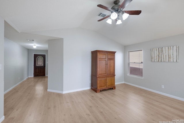 empty room with ceiling fan, light wood-style floors, baseboards, lofted ceiling, and visible vents