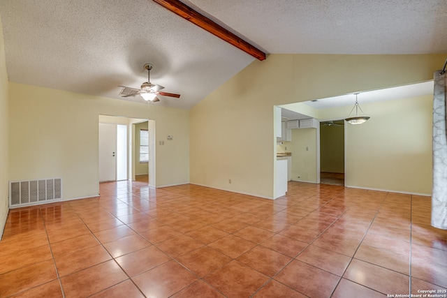 spare room featuring ceiling fan, a textured ceiling, vaulted ceiling with beams, light tile patterned floors, and visible vents