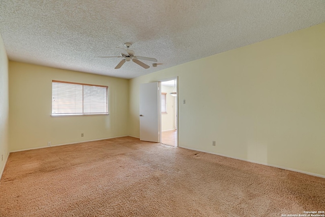 empty room with a textured ceiling, ceiling fan, light colored carpet, and baseboards