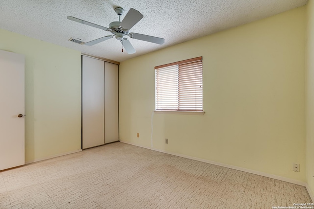 unfurnished bedroom with a ceiling fan, a textured ceiling, visible vents, and a closet