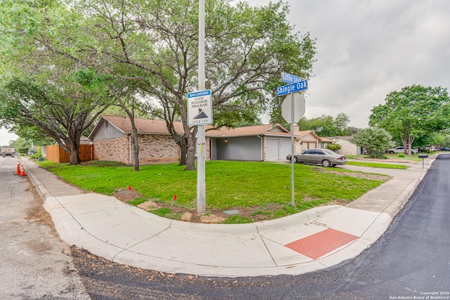 view of front of property featuring a garage, fence, and a front lawn
