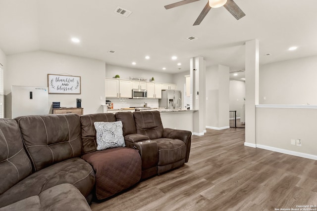 living room with visible vents, a ceiling fan, baseboards, and wood finished floors