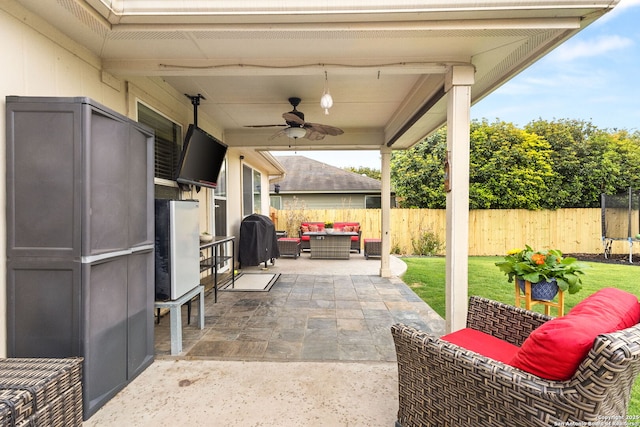 view of patio / terrace featuring ceiling fan, an outdoor living space, a fenced backyard, and a trampoline
