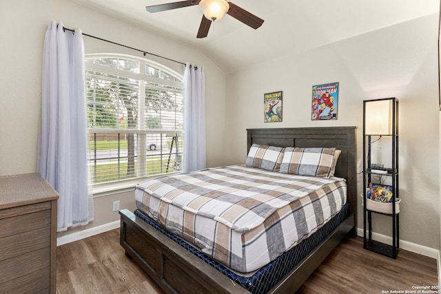 bedroom featuring baseboards, lofted ceiling, multiple windows, and wood finished floors