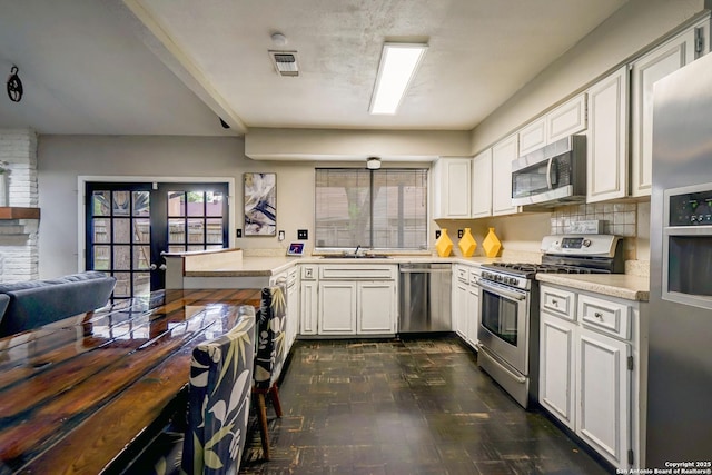 kitchen featuring visible vents, light countertops, appliances with stainless steel finishes, and a peninsula