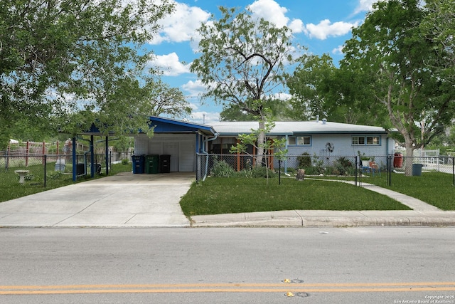 view of front of home with an attached carport, concrete driveway, fence private yard, and a front yard