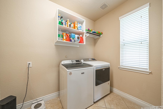 laundry area featuring visible vents, laundry area, baseboards, independent washer and dryer, and light tile patterned floors
