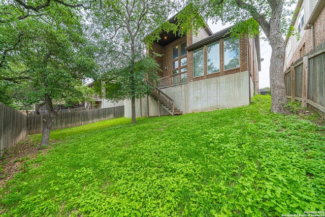view of yard with stairs and a fenced backyard