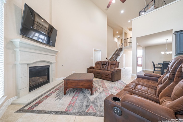 tiled living room with baseboards, ceiling fan, a premium fireplace, and high vaulted ceiling