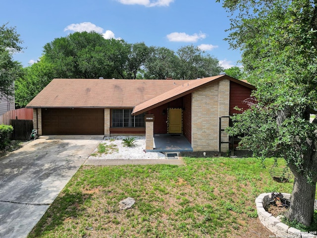 view of front of house featuring fence, brick siding, a garage, a front yard, and driveway