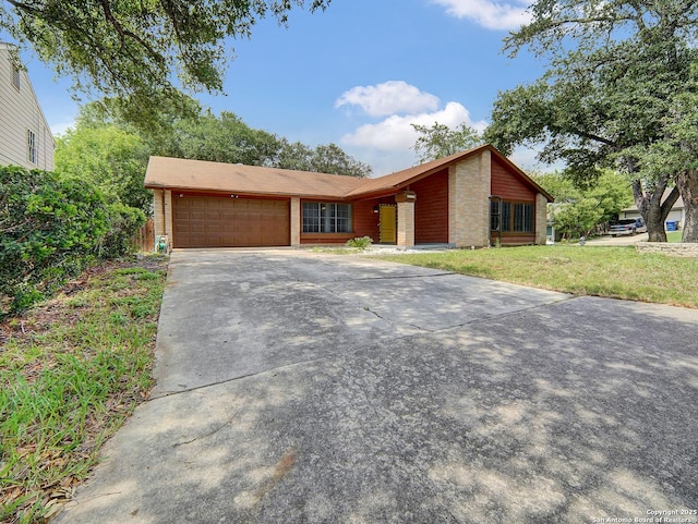 view of front facade featuring a garage, a front lawn, and concrete driveway