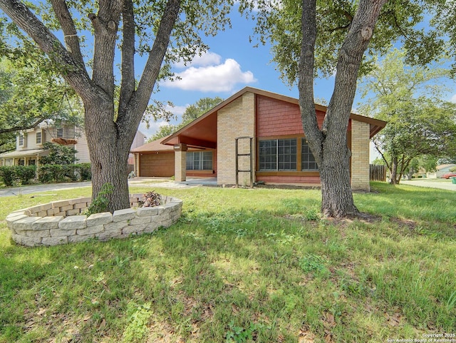 back of property with brick siding, an attached garage, a lawn, and concrete driveway