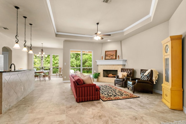 300 Knoll Spgs, Boerne, TX 78006 - living room with a lit fireplace, a ceiling fan, visible vents, baseboards, and a tray ceiling