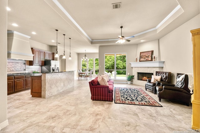 300 Knoll Spgs, Boerne, TX 78006 - living area with visible vents, ornamental molding, ceiling fan, a warm lit fireplace, and a tray ceiling