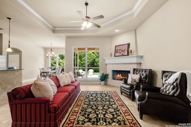 300 Knoll Spgs, Boerne, TX 78006 - living room with crown molding, a raised ceiling, a glass covered fireplace, and ceiling fan with notable chandelier