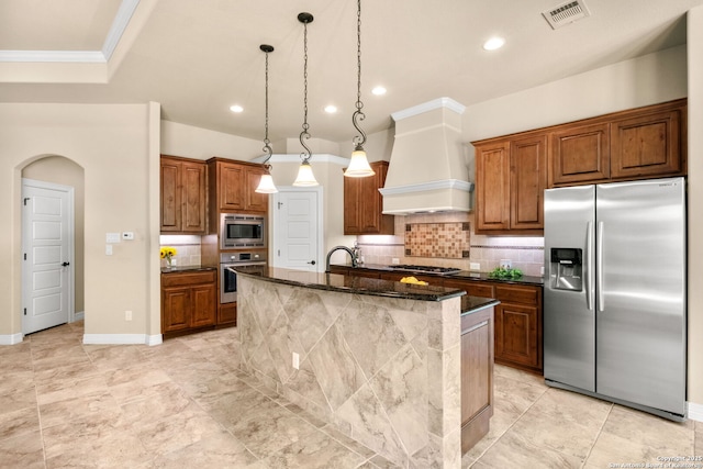 300 Knoll Spgs, Boerne, TX 78006 - kitchen featuring brown cabinets, appliances with stainless steel finishes, premium range hood, tasteful backsplash, and visible vents