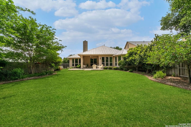 300 Knoll Spgs, Boerne, TX 78006 - rear view of property featuring a fenced backyard, a chimney, a patio area, a standing seam roof, and a lawn