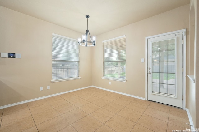 interior space with baseboards, a notable chandelier, and light tile patterned floors