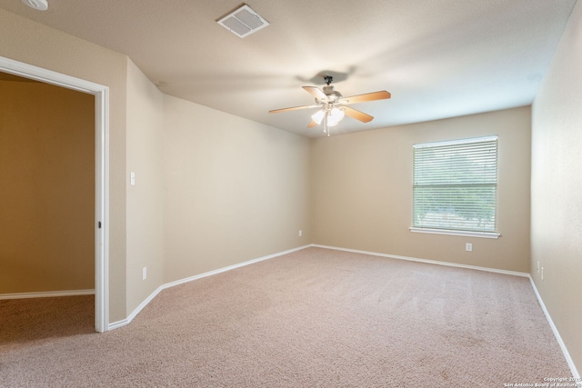carpeted spare room with a ceiling fan, baseboards, and visible vents