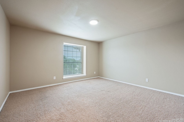 carpeted spare room with baseboards