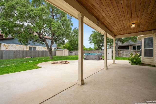 view of patio with a storage shed, an outdoor structure, a fire pit, and a fenced backyard