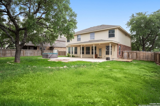 back of property with a patio, a fenced backyard, a hot tub, and brick siding