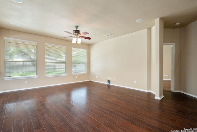 empty room featuring baseboards, ceiling fan, a healthy amount of sunlight, and wood finished floors