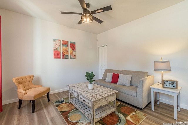 living room featuring baseboards, ceiling fan, and wood finished floors