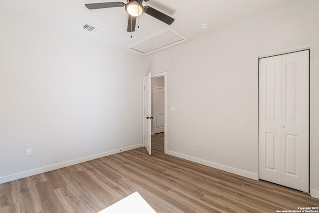 unfurnished bedroom featuring a ceiling fan, visible vents, baseboards, a closet, and light wood-style floors