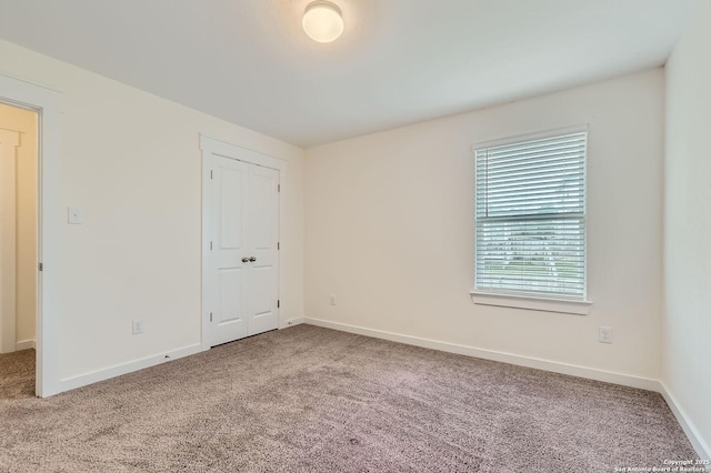 unfurnished room featuring baseboards and carpet