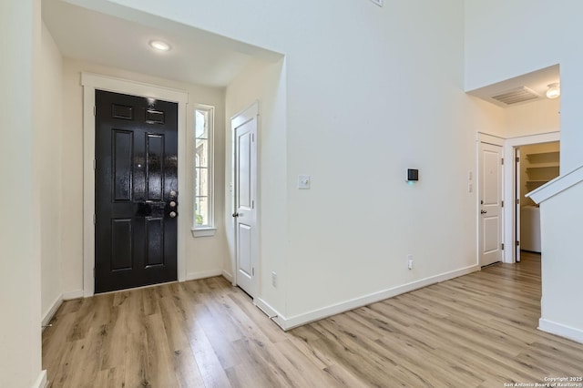 entryway with light wood-style floors, baseboards, recessed lighting, and visible vents