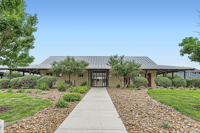 view of front of home featuring stucco siding, metal roof, and a standing seam roof