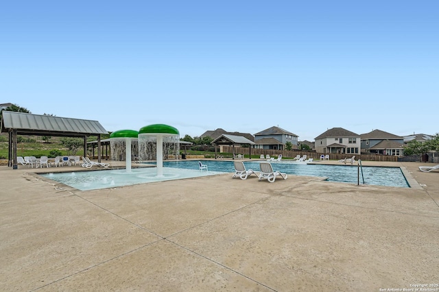 community pool featuring fence, a gazebo, a patio area, and a residential view