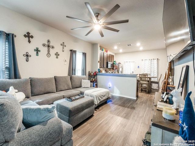 living area featuring recessed lighting, a ceiling fan, and light wood finished floors