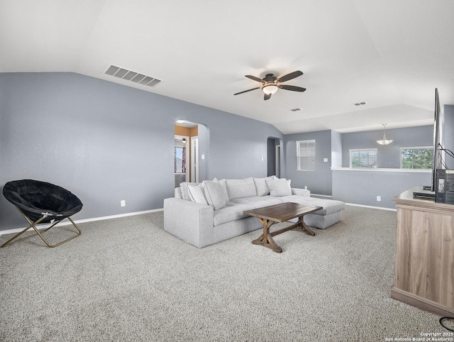 living area with visible vents, carpet flooring, ceiling fan, arched walkways, and vaulted ceiling