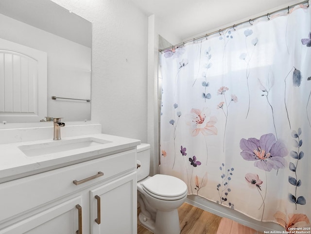 full bath with vanity, wood finished floors, and toilet