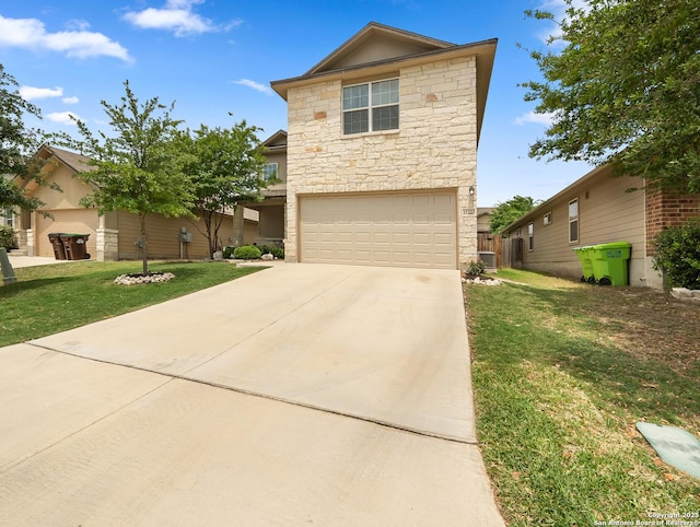traditional-style home featuring a garage, concrete driveway, a front lawn, and stone siding