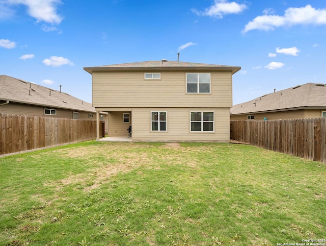 back of property featuring a yard, a fenced backyard, and a patio area