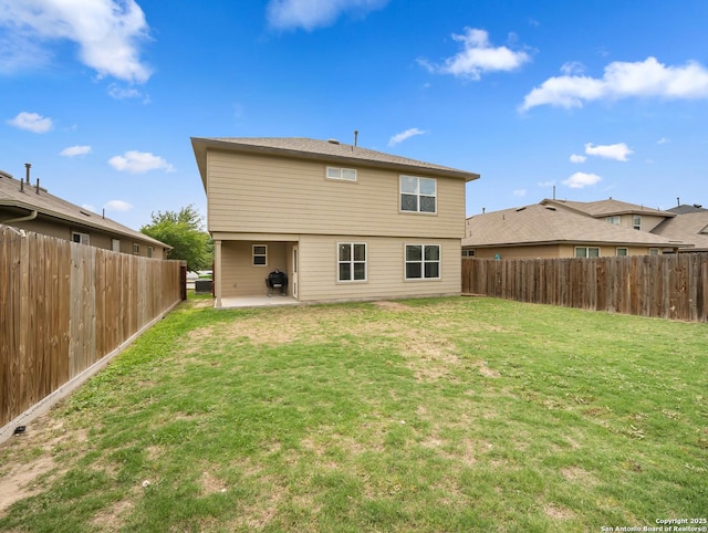 back of house featuring a yard, a patio, and a fenced backyard