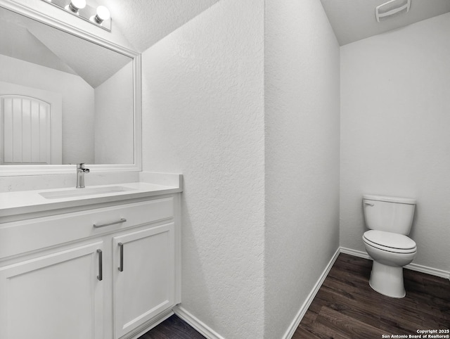 bathroom with visible vents, wood finished floors, vanity, baseboards, and toilet