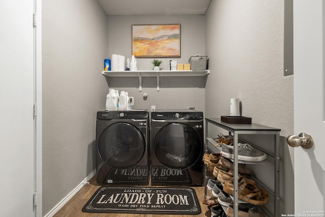 laundry area featuring baseboards, laundry area, washer and clothes dryer, and wood finished floors