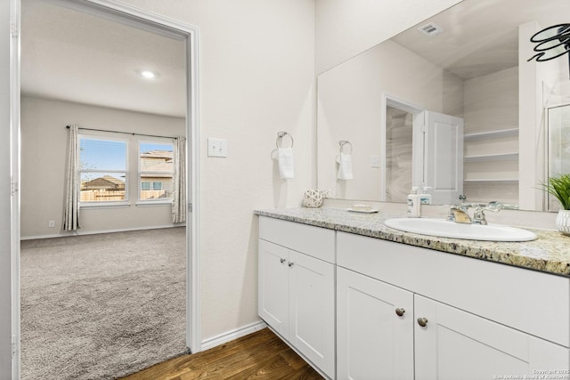 bathroom featuring vanity, baseboards, and visible vents