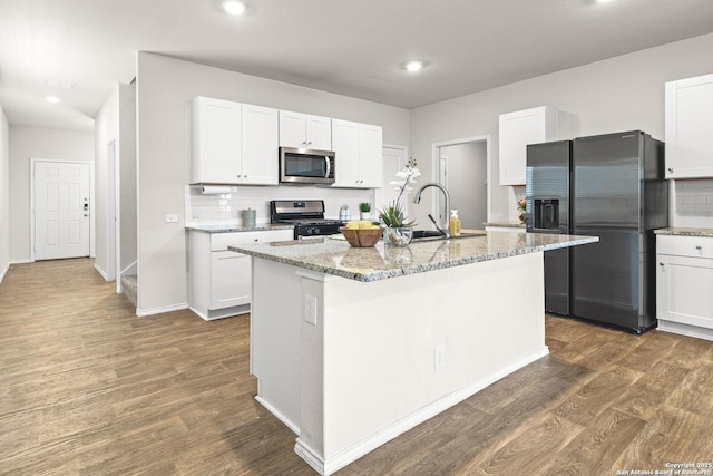kitchen featuring dark wood-style floors, recessed lighting, tasteful backsplash, a sink, and appliances with stainless steel finishes