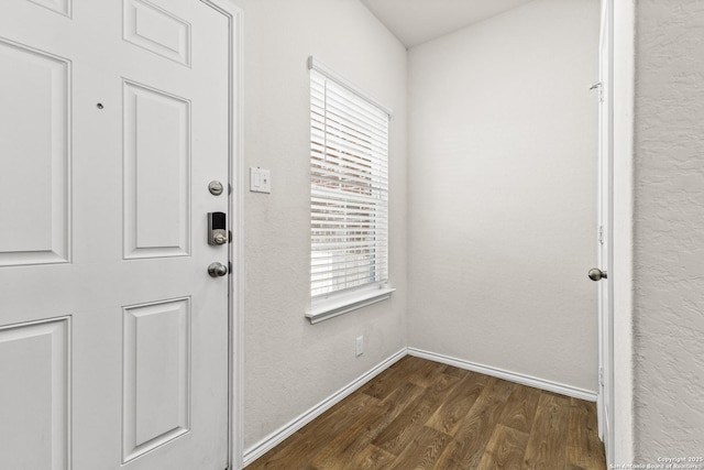 doorway to outside featuring baseboards, plenty of natural light, and dark wood-style flooring