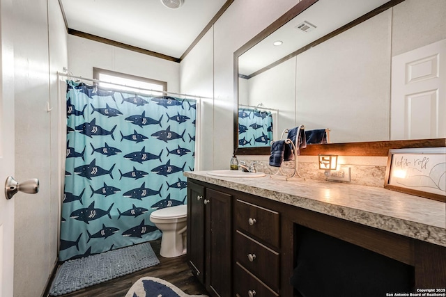 bathroom featuring crown molding, visible vents, vanity, wood finished floors, and toilet