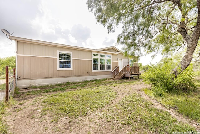 rear view of property featuring stairs and a deck