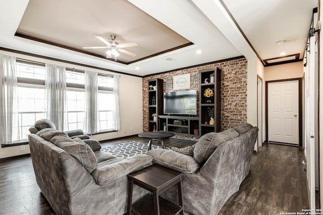living area with crown molding, ceiling fan, a tray ceiling, and dark wood-style flooring