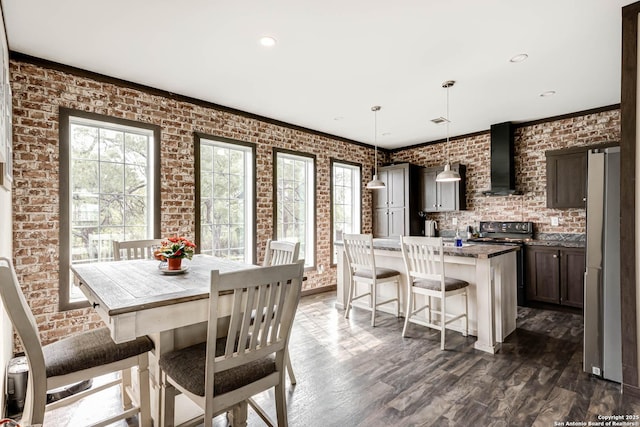 dining room with dark wood-style flooring, brick wall, and recessed lighting
